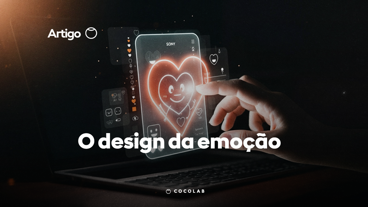 Tela de computador ou smartphone com um coração na tela e uma pessoa tocando. A imagem é 3D e tem um texto na imagem "O design da emoção". O propósito da imagem é passar a mensagem de que um bom design é aquele de desperta emoção no receptor.